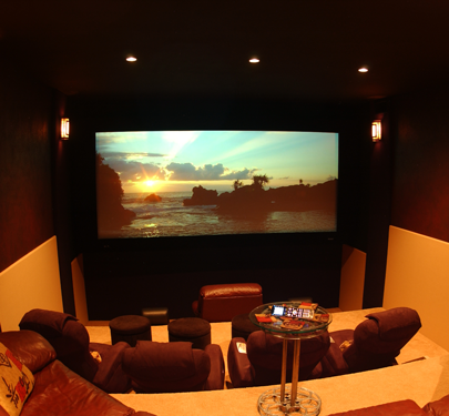 Multi-tiered home theater with projection screen showing a sunset